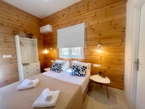 a bedroom with a bed in a wooden wall at Sea and Sand Elafonisos in Elafonisos