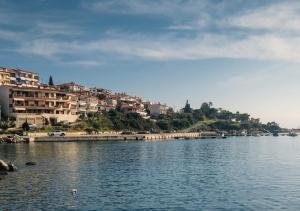 a large body of water with buildings in the background at Aqua Mare Seaside Experience in Pyrgadikia