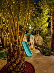 a palm tree with a slide and a playground at Hotel Jacob in Ureki