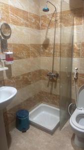 a bathroom with a shower with a toilet and a sink at فندق منازل الراشدين in Az Zahrāʼ