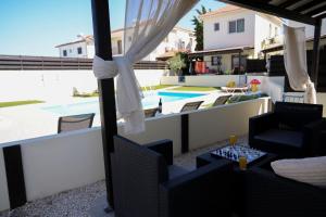 a balcony with a view of a swimming pool at Villa Paradise Complex - Pyla Larnaca in Pyla