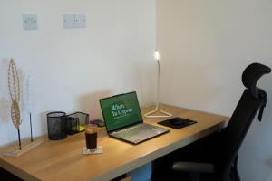 a laptop computer sitting on top of a wooden desk at Villa Paradise Complex - Pyla Larnaca in Pyla