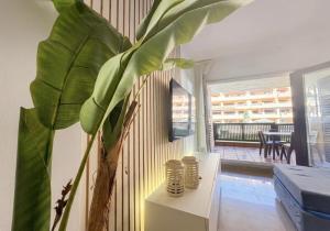 a living room with a plant and a table at Musa apartamentos in El Ejido