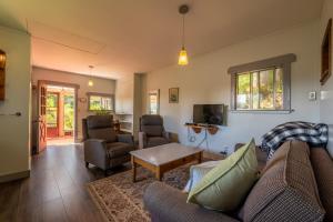 a living room with a couch and chairs and a table at Woods End Landing in Bamfield