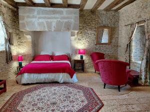 a bedroom with a bed and two red chairs at Chambre entrée indépendante dans tour du 15ème siècle in Mauvières