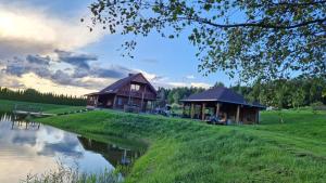 a couple of buildings on the side of a lake at Relax House in Varkaliai