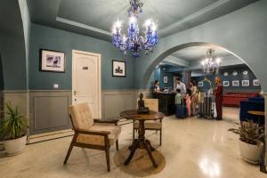 a lobby with a chandelier and a table and people at Victoria Mansion - A Signature Collection by HST Hotels in Udaipur +88 photos