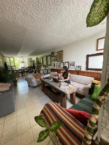 a woman sitting on a couch in a living room at Hostal Casa Las Tías in Medellín