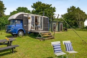 an rv parked in a yard with two chairs and a table at 1 Bed in Elsing oc-d44229 in Elsing
