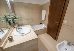 a bathroom with two sinks and a tub with a vase of flowers at Musa apartamentos in El Ejido +2 photos