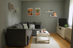 a living room with a gray couch and a table at Green Paradise in Vrnjačka Banja