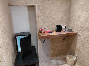 a wall with a wooden counter with a television on it at Chambre entrée indépendante dans tour du 15ème siècle in Mauvières