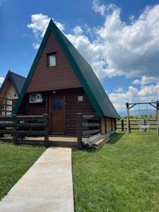a barn with a green roof on a field at Warm home 2 Zabljak in Žabljak