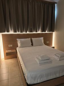 a bedroom with a bed with white sheets and a window at Litmus apartment 4 in Karlovasi