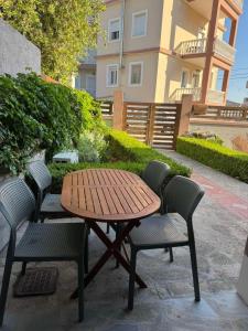 a wooden table and four chairs around a wooden table and chairs at Litmus apartment 4 in Karlovasi