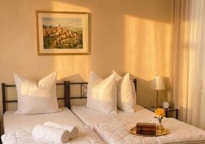 a bed with white pillows and a tray of towels at Residenz Halberstädter Domschatz beliebt bei Monteuren Einzelbetten WlAN in Halberstadt
