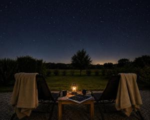 a table and two chairs under a night sky with stars at Studio bois Le Colibri à Chambley in Hagéville
