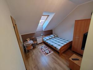an attic bedroom with a bed and a window at Agroturystyka Biedrzycki in Nowe Guty