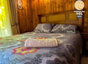 a bed with a pillow on top of it at Cabañas Loncoche Puerta del Sol in Loncoche