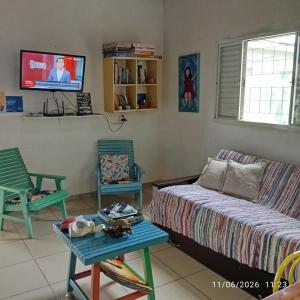 a living room with a couch and chairs and a tv at Singela Casa em Chapada dos Guimarães in Chapada dos Guimarães