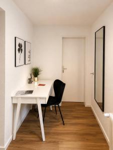 a white desk with a black chair in a room at Modernes Appartement mit Balkon & Parkplatz - Waldshut-Tiengen in Waldshut-Tiengen