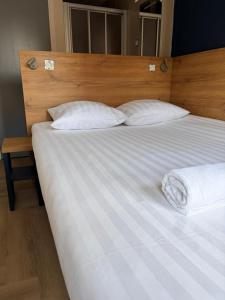 a large bed with white sheets and pillows at Hotel Continental Amsterdam in Amsterdam