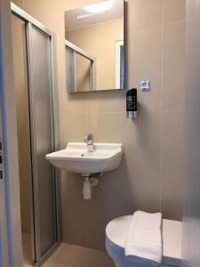 a bathroom with a sink and a toilet and a mirror at Hotel Continental Amsterdam in Amsterdam