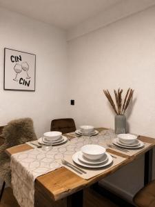 a wooden table with plates and utensils on it at Modernes Appartement mit Balkon & Parkplatz - Waldshut-Tiengen in Waldshut-Tiengen