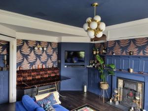 a living room with blue walls and a fireplace at Beautiful ground floor 2 bed flat in Camberley