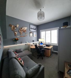 a living room with a couch and a desk with a computer at Beautiful ground floor 2 bed flat in Camberley