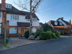 a house with a tree on the side of the street at Beautiful ground floor 2 bed flat in Camberley