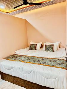 a bed in a corner of a room at Hotel Avigatkabir sanwer in Sānwer