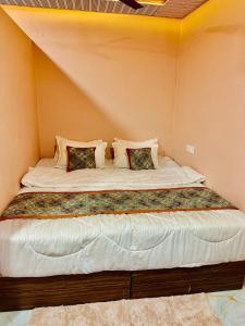 a large bed in a corner of a room at Hotel Avigatkabir sanwer in Sānwer