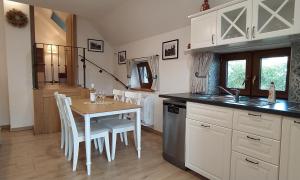 a kitchen with a table and white cabinets and a table and chairs at Starý dvůr pod Pálavou - Sýpka in Šakvice