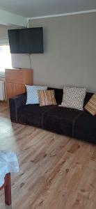 a black couch sitting in a living room at Siedlisko na Skarpie in Garcz