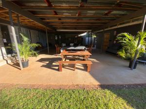 a wooden picnic table sitting on a patio at Slaapnet Guesthouse Long Stay Accommodation Wilkoppies in Klerksdorp