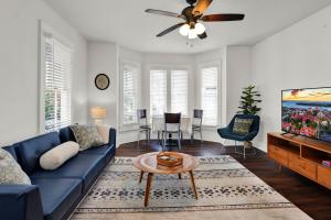 a living room with a blue couch and a ceiling fan at Cedar Street Retreat - Unit C in St. Augustine