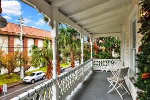 a white porch with a table and a car on it at Cedar Street Retreat - Unit C in St. Augustine