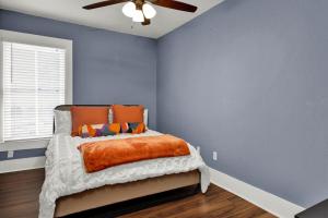 a bedroom with blue walls and a bed with an orange blanket at Cedar Street Retreat - Unit C in St. Augustine