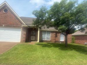 a brick house with a tree in the yard at The Relaxing Home in Memphis