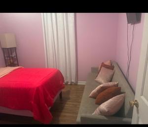 a bedroom with a bed and a couch with a red blanket at The Relaxing Home in Memphis +7 photos
