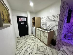 ein Badezimmer mit Marmorboden und Waschbecken in der Unterkunft Desami Hotel in Omole