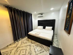 ein kleines Schlafzimmer mit einem Bett und einem großen Teppich in der Unterkunft Desami Hotel in Omole