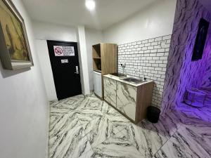 ein Badezimmer mit Marmorboden und Waschbecken in der Unterkunft Desami Hotel in Omole