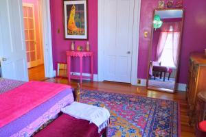 a bedroom with purple walls and a bed and a mirror at The Sanctuary on Washington in Norwich