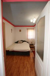 a bedroom with a bed and a cross on the wall at Kicsipatak vendégház in Lunca de Sus