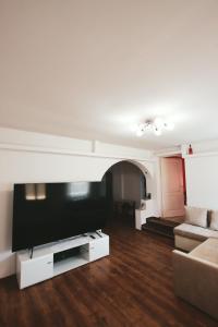 a living room with a large flat screen tv at Kicsipatak vendégház in Lunca de Sus