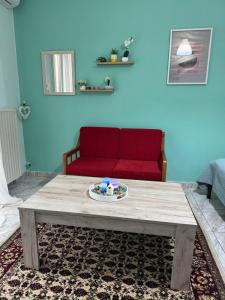 ein Wohnzimmer mit einem roten Sofa und einem Couchtisch in der Unterkunft valantis room in Kavala + 8 Fotos