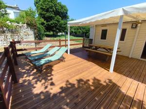 a wooden deck with two lounge chairs and an umbrella at l'instant provence in Pradons