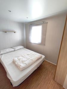 a bedroom with a white bed and a window at l'instant provence in Pradons